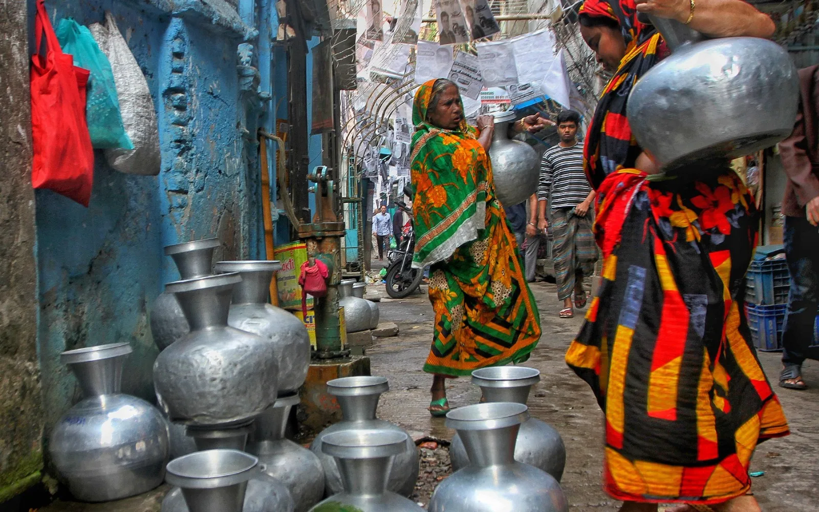 People collect and use water during a neighbourhood water shortage.